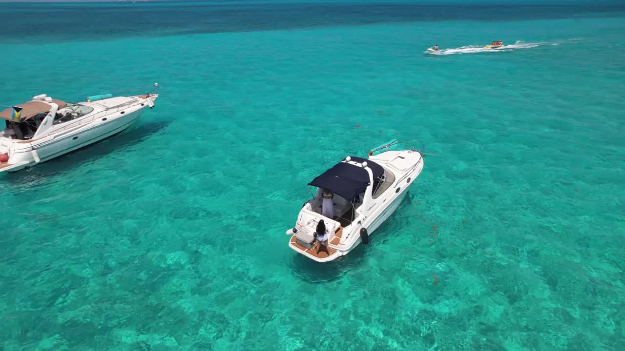Yates navegando por el agua clara que hace famoso a Cancún